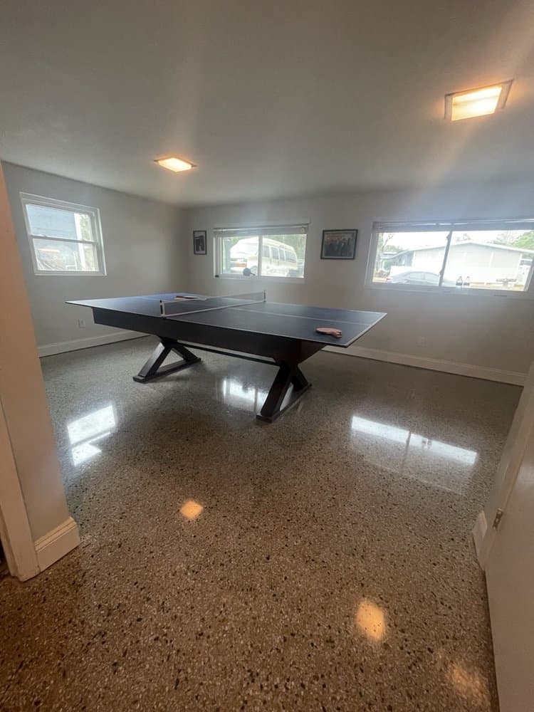 Polished dark terrazzo floor in a game room with a ping pong table