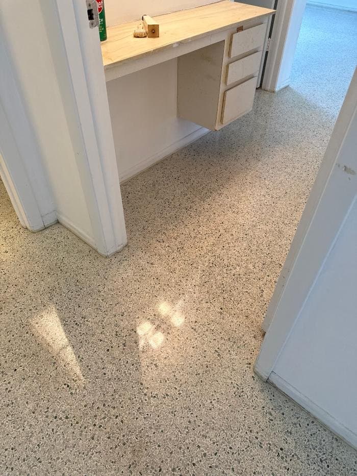 Clean terrazzo hallway floor with green and gray aggregate through a home’s doorways