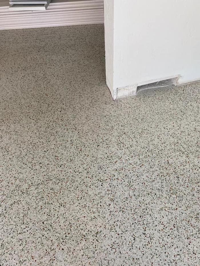 Honed terrazzo floor with a light gray base and green and red aggregate chips