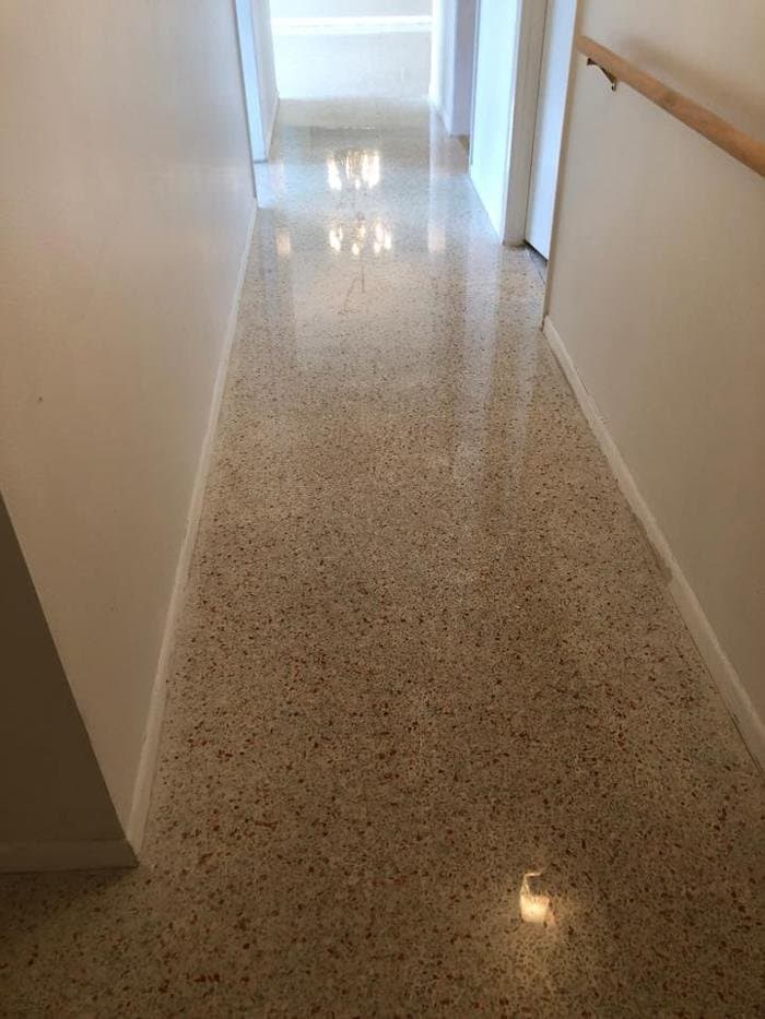 Polished terrazzo hallway with red and tan chips in a mid-century Florida home