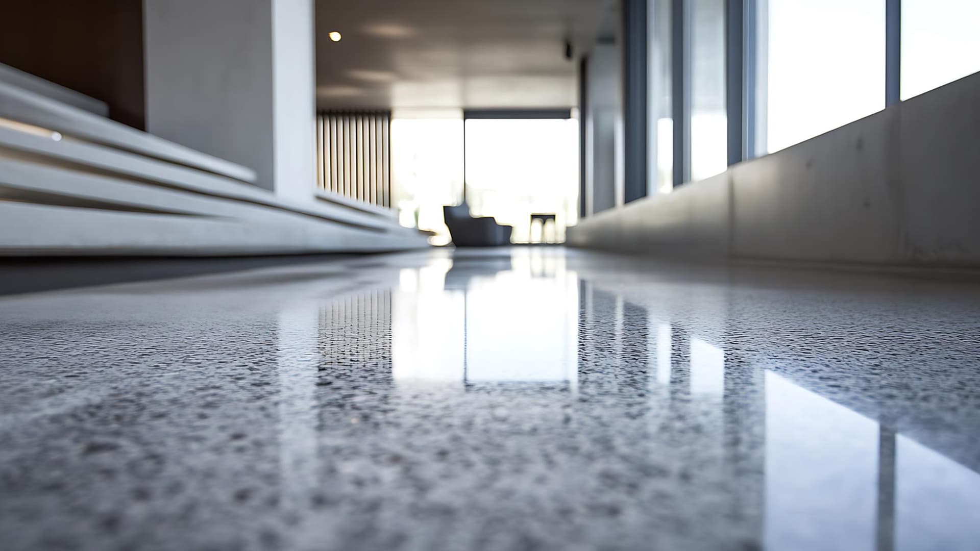 Yellowed, wax‑coated terrazzo floor next to a clean section